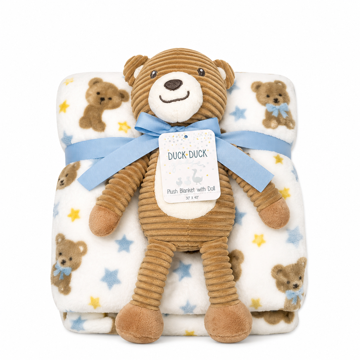 A teddy bear plush toy wrapped in a light blue ribbon with a hanging tag reading 'DUCK DUCK', placed on top of a folded cream plush blanket printed with brown teddy bears, blue stars, and yellow stars.