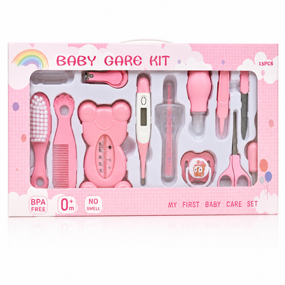 A pink baby care kit in its retail packaging, containing 15 pieces of baby hygiene tools such as a hairbrush, comb, thermometer, nail clipper, and scissors.
