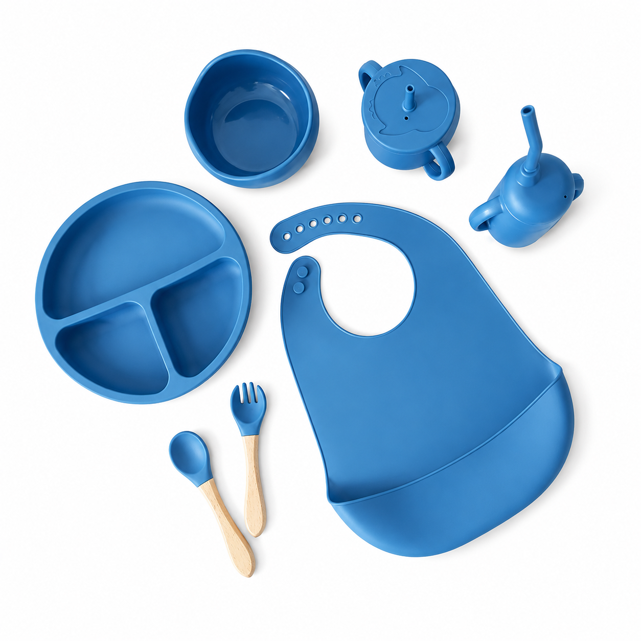 A blue baby feeding set arranged on a white background, including a divided plate, bib, bowl, sippy cup, small pitcher, spoon, and fork. The utensils have light wood handles.