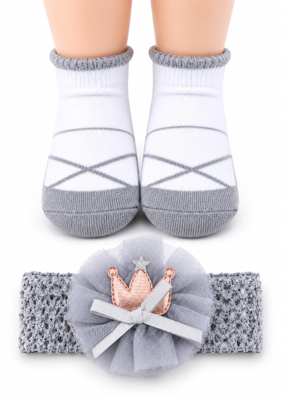 Baby socks with gray cuffs and a matching headband with a flower and crown design on a white background.