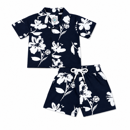 A two-piece kids' short-sleeve set featuring a navy blue camp collar button-up shirt and matching drawstring shorts, both with a white floral print, displayed on a solid white background.