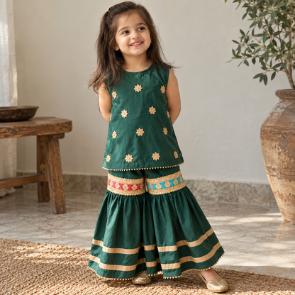 Child model wearing BabyCo emerald green sleeveless kurti and sharara traditional girls eastern wear with gold star detailing