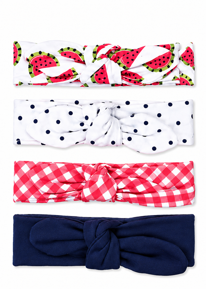 Four fabric headbands with knotted centers, shown vertically on a white background. The top headband has a watermelon print on white, the second is white with navy polka dots, the third is red and pink gingham, and the bottom one is solid navy blue.