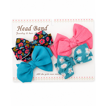 A set of 4 colorful fabric headbands displayed on a white retail backing card. The collection includes solid bright pink, solid turquoise blue, teal with white daisy print, navy floral print, and a small matching floral piece.