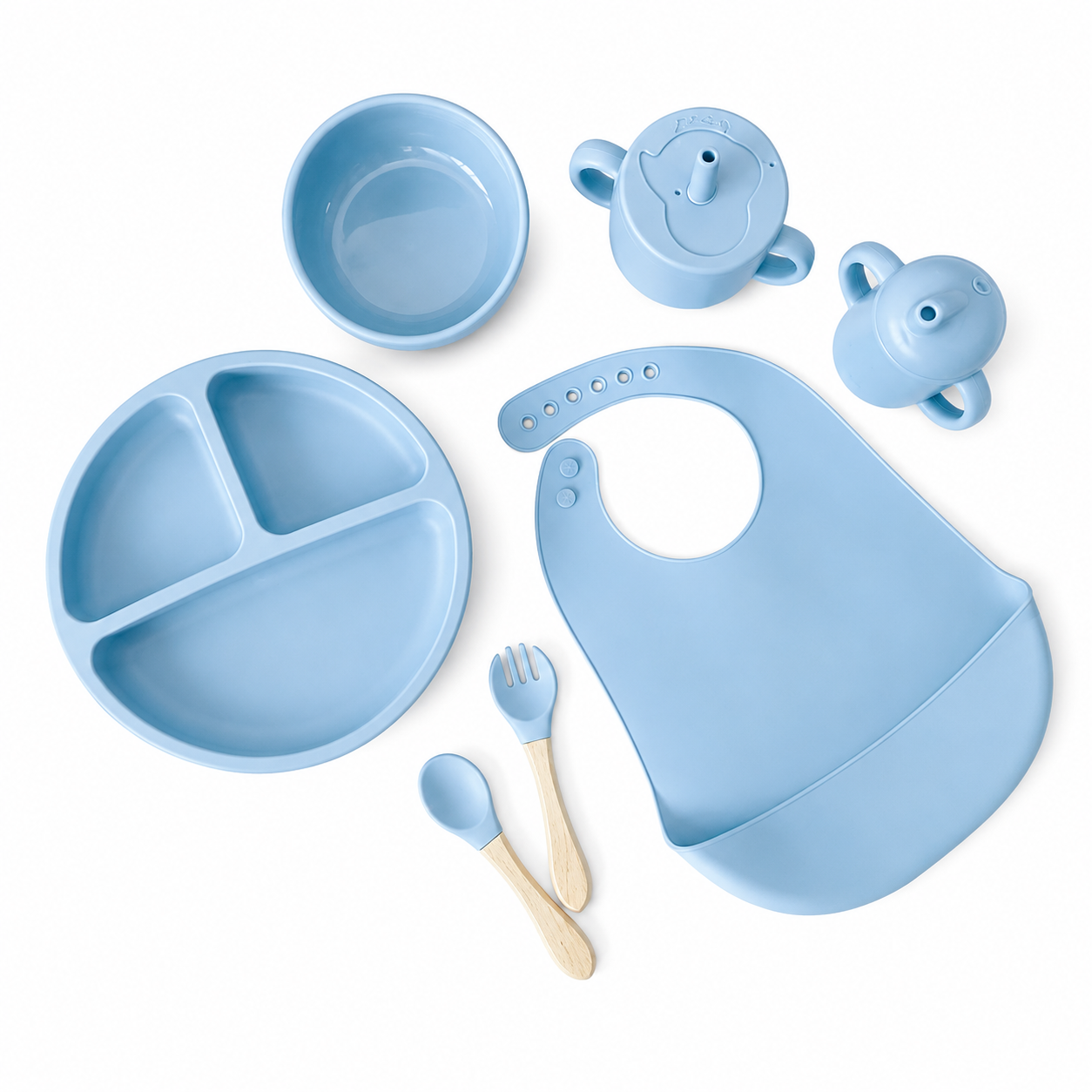 A light blue silicone baby feeding set arranged on a white background, including a divided plate, bib, bowl, sippy cup, spoon, and fork with natural wood handles.