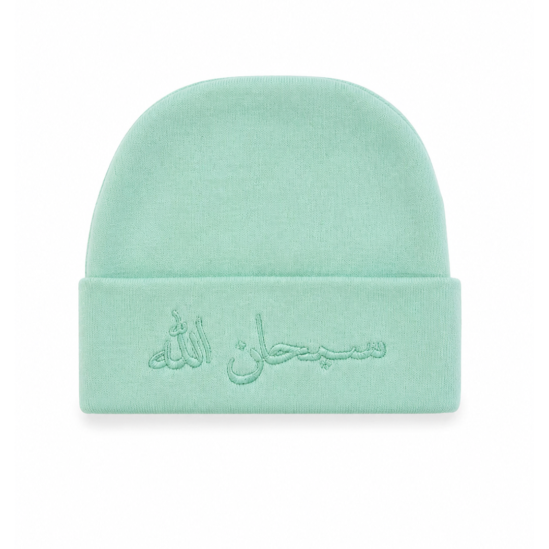 A mint green knit beanie hat with Arabic calligraphy embroidered on the front cuff, shown against a plain white background.